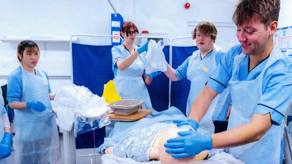 Photo of a group of young people in a hospital setting in scrubs