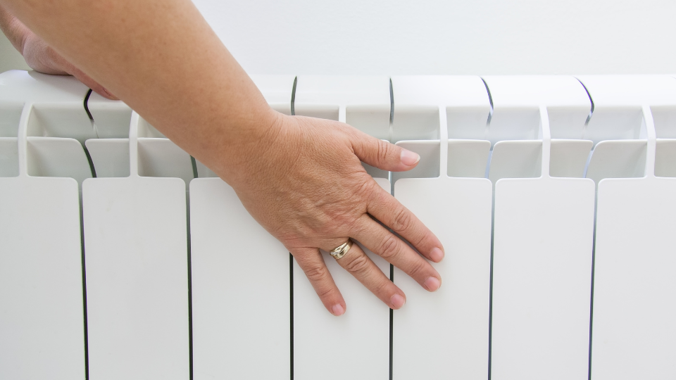White radiator with a woman's hand on it.